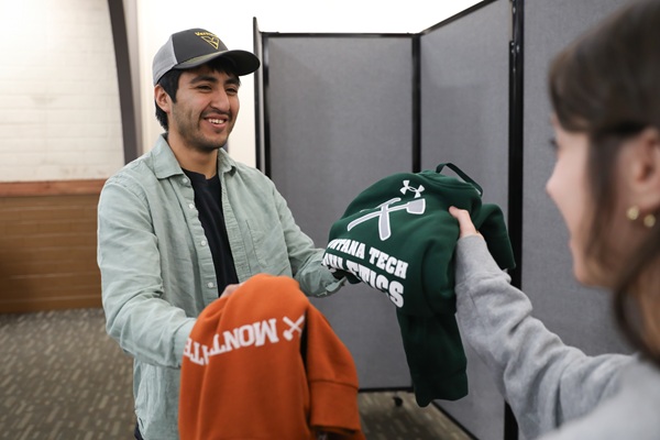 Two students exchange Montana Tech sweaters 