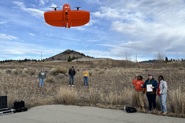 students watch a drone rise