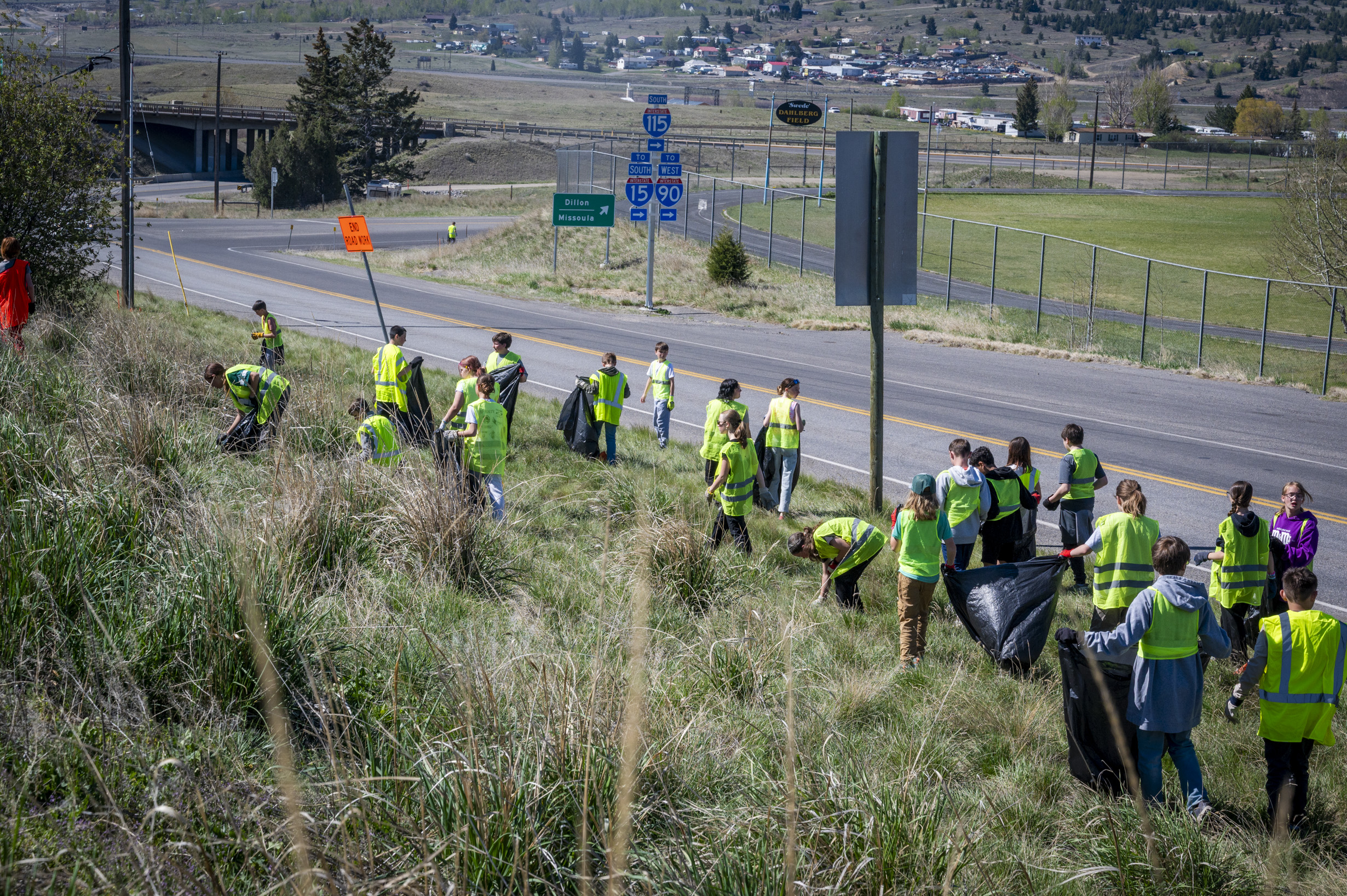 students working in open grasslands by roadside