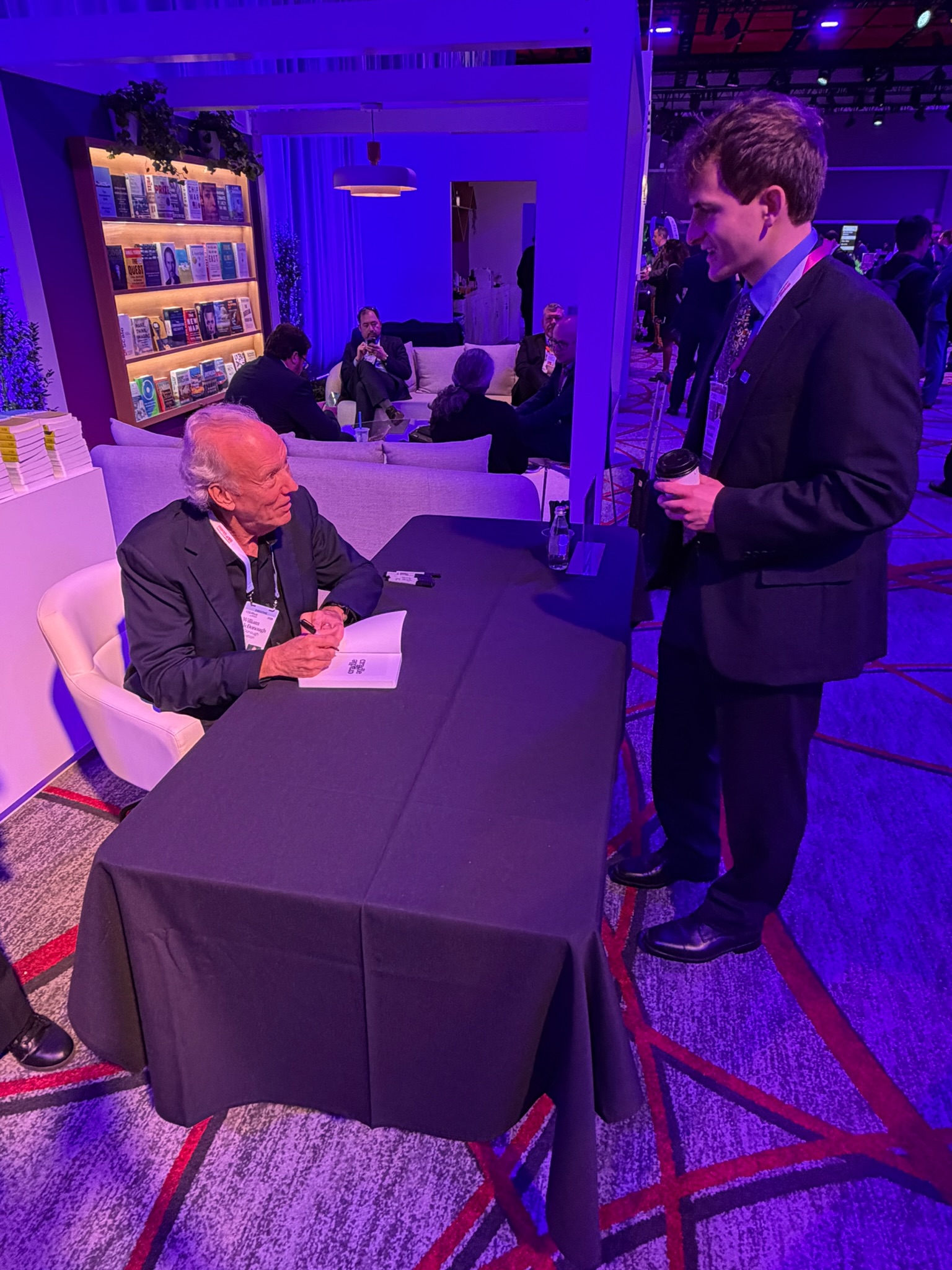 William McDonough signs a copy of Cradle to Cradle for Andrew Woods at CERA Week. 