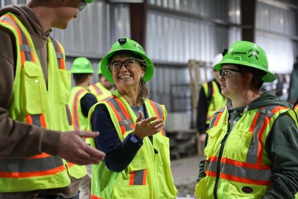 Robin Bullock talks with students, all in hardhats