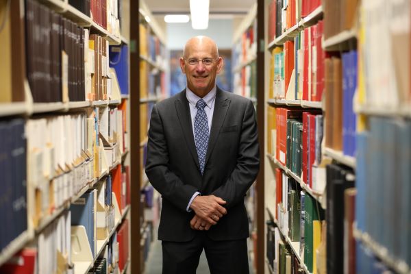 Bob Morris stands in between book stacks in Montana Tech's library