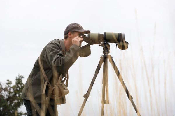 Caleb Lashway looks through a spotting scope