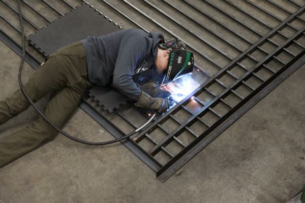 A student welds a fence. 