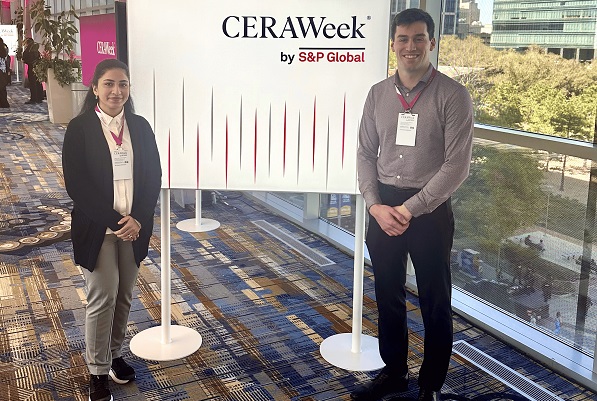 Two students stand with CERAWeek sign.