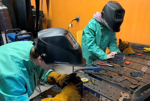 2 students work in a welding helmet