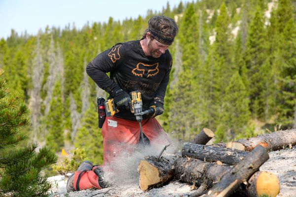 Daniel Kelly drills a hole in soil