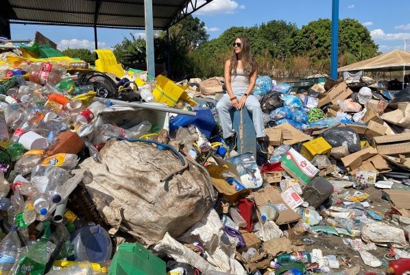 Tara Zolnikov sits on a mountain of trash